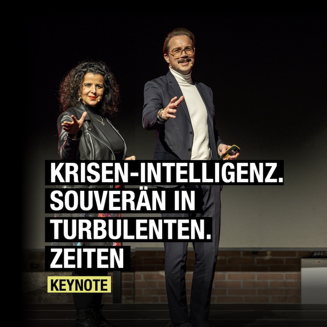 Zwei Redner präsentieren eine Keynote über Krisen-Intelligenz und souveräne Handlungen in turbulenten Zeiten.
