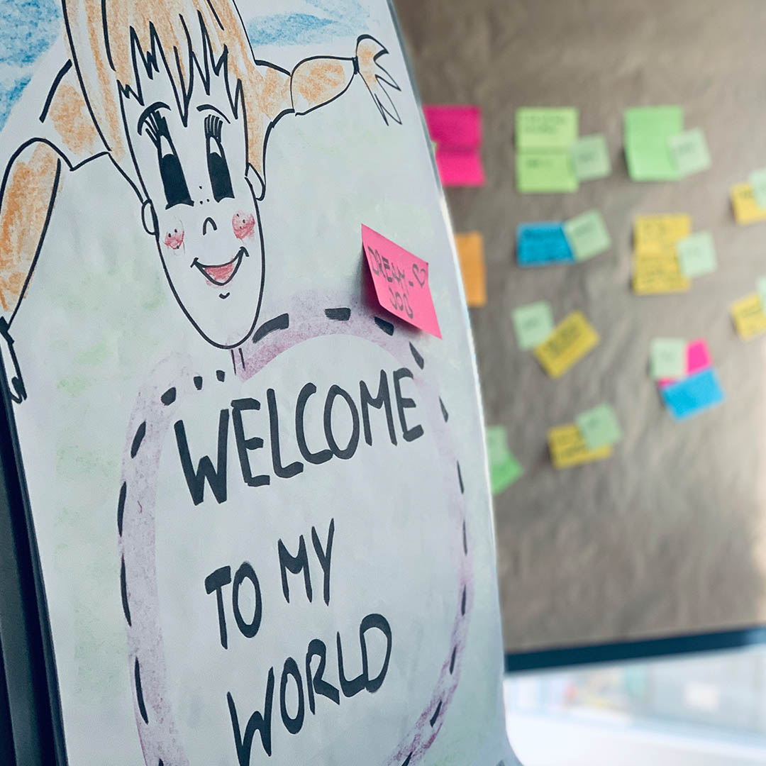 Colorful drawing with text Welcome to My World and sticky notes in the background, indicating a creative brainstorming space.